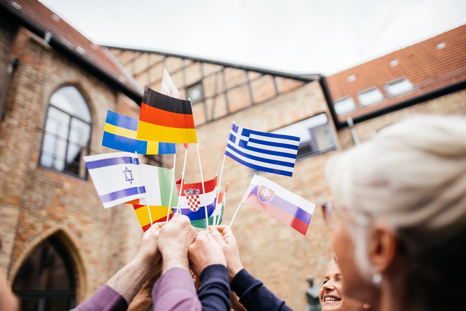 Fahnen unterschiedlicher Länder werden in die Höhe gehalten