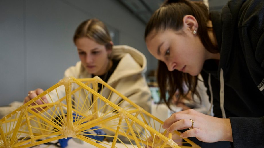 Making-Of Foto, Studierende beim Bau einer Spaghetti-Brücke