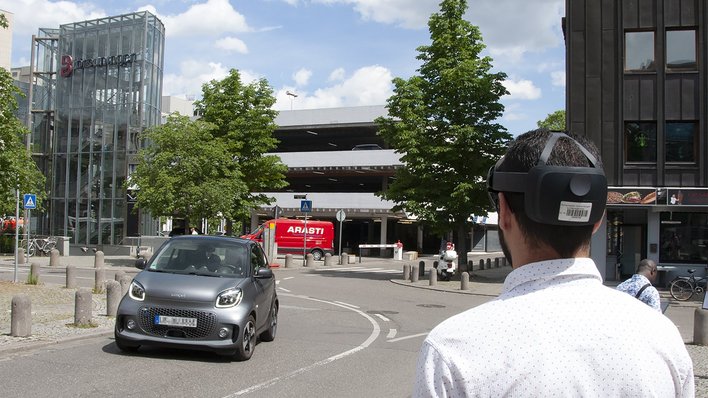 Ein Mann schaut mit VR-Brille in eine gewundene Straße 