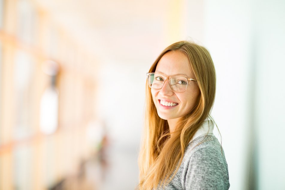 Eine Studentin schaut lachend in die Kamera